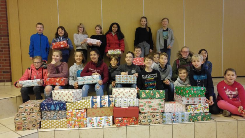 Teamschüler schnüren Weihnachtspäckchen für Kinder in Not
